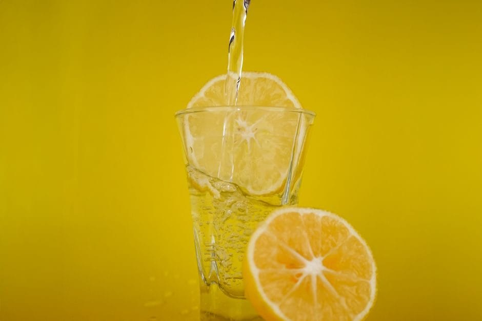 Bicchiere d'acqua con limone su un tavolo in una giornata estiva